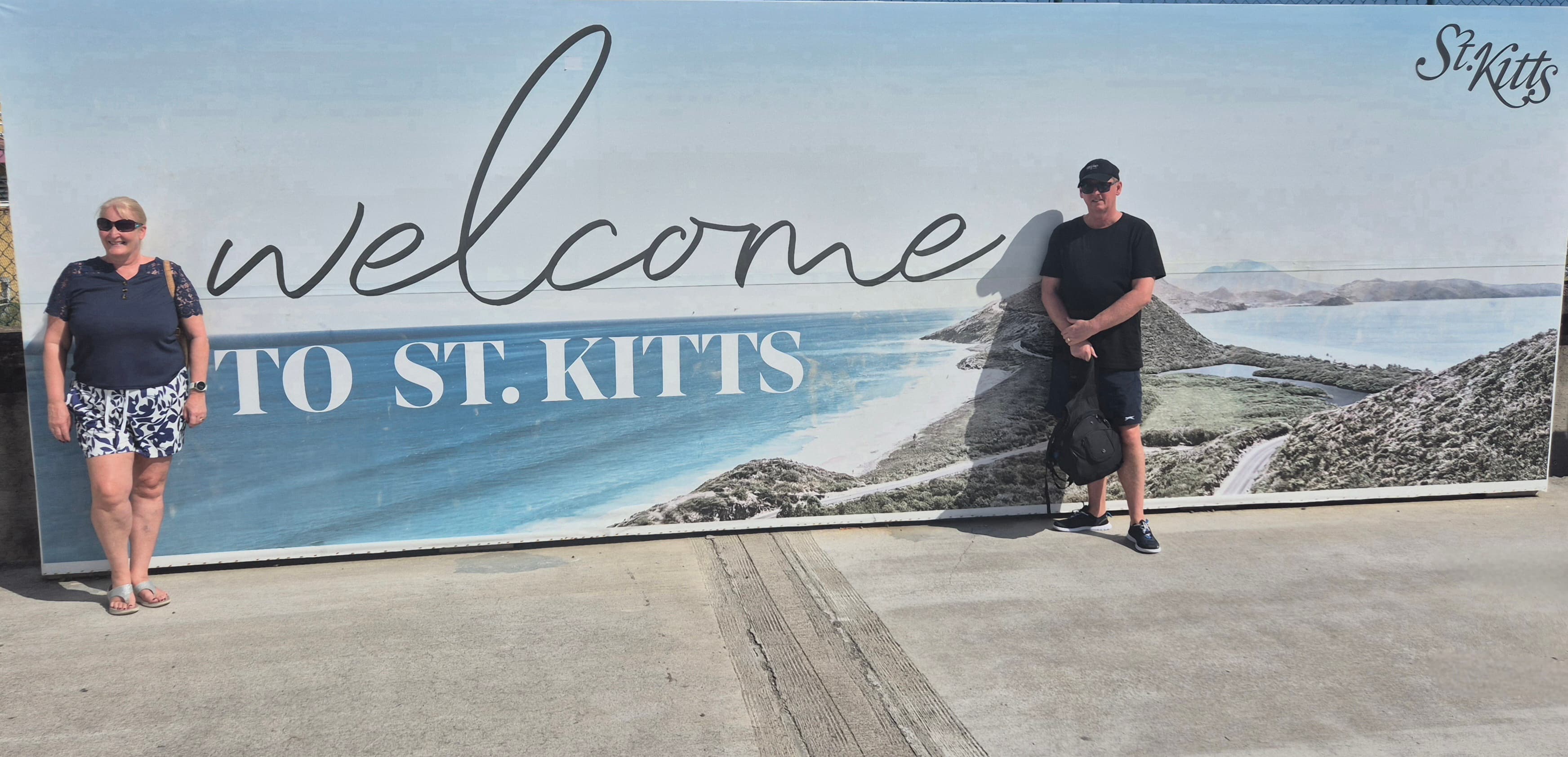 Paul and his wife at the welcome sign in St Kitts